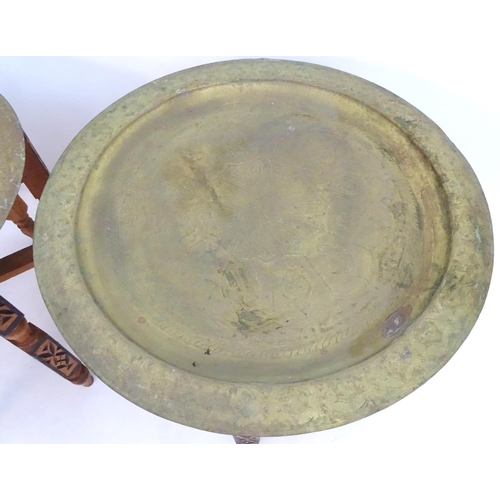 2216 - A pair of early 20thC brass top tables with incised tray tops and painted folding bases. 21 1/4