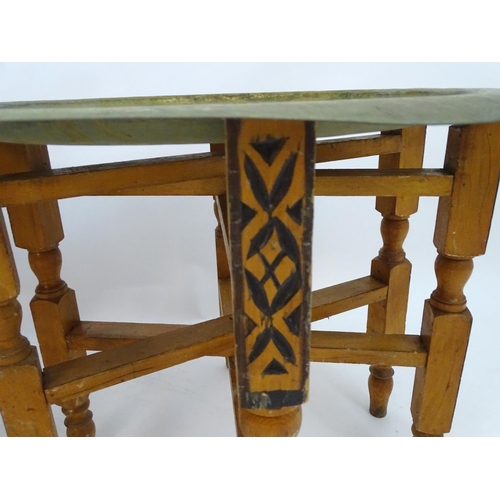 2216 - A pair of early 20thC brass top tables with incised tray tops and painted folding bases. 21 1/4