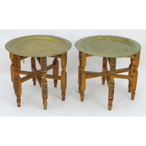 2216 - A pair of early 20thC brass top tables with incised tray tops and painted folding bases. 21 1/4