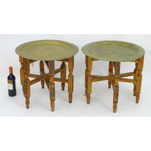 2216 - A pair of early 20thC brass top tables with incised tray tops and painted folding bases. 21 1/4