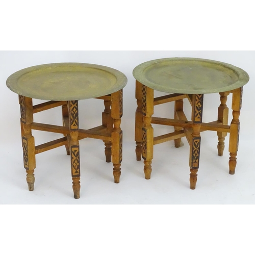 2216 - A pair of early 20thC brass top tables with incised tray tops and painted folding bases. 21 1/4