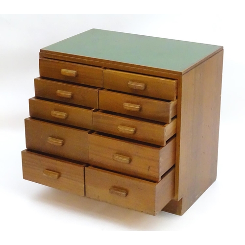 2219 - A mid 20thC cedar chest of drawers, comprising two flights of five drawers, with inset green vinyl t... 