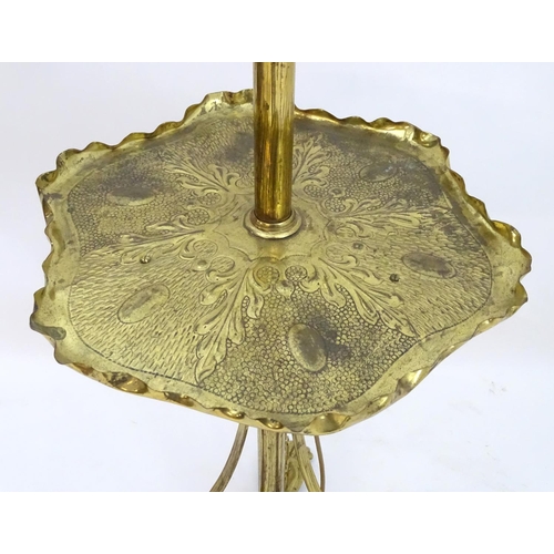 2246 - A 19thC Arts and Crafts brass standard lamp, converted to electricity, the height adjustable shaft s... 