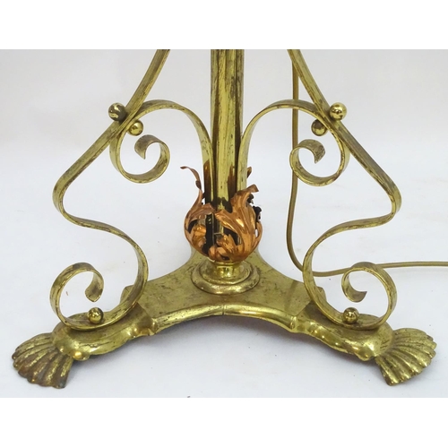 2246 - A 19thC Arts and Crafts brass standard lamp, converted to electricity, the height adjustable shaft s... 