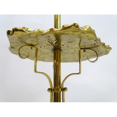 2246 - A 19thC Arts and Crafts brass standard lamp, converted to electricity, the height adjustable shaft s... 