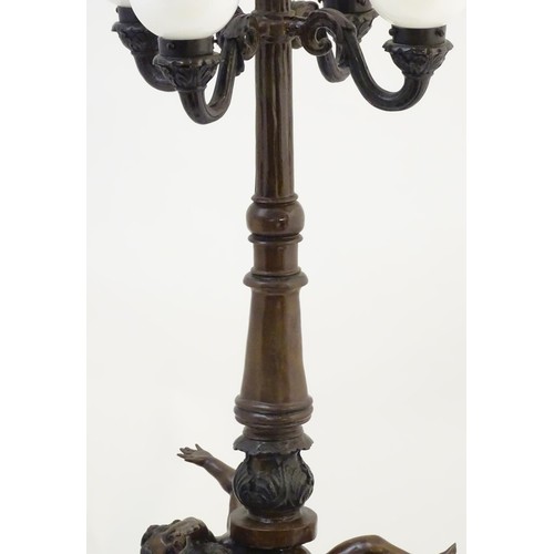 2247 - A 20thC bronze lamp with 5 glass globe shades. The central column supported by putti. the whole appr... 