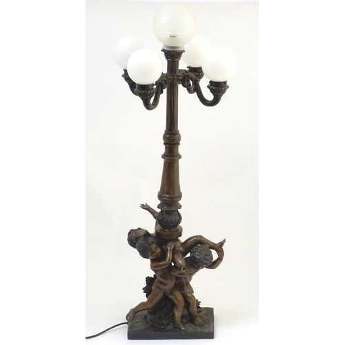 2247 - A 20thC bronze lamp with 5 glass globe shades. The central column supported by putti. the whole appr... 