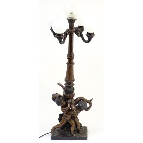 2247 - A 20thC bronze lamp with 5 glass globe shades. The central column supported by putti. the whole appr... 