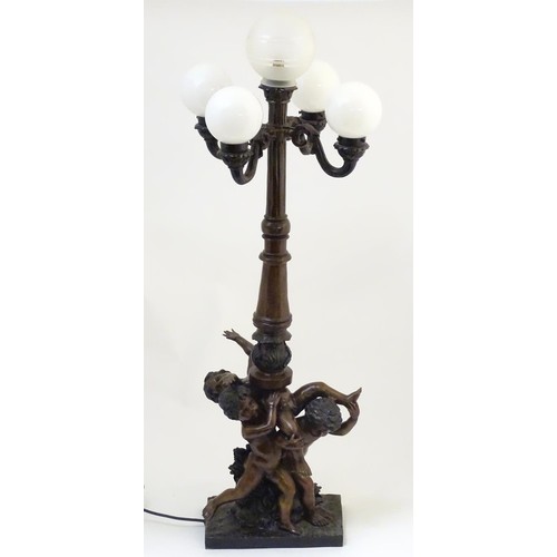 2247 - A 20thC bronze lamp with 5 glass globe shades. The central column supported by putti. the whole appr... 