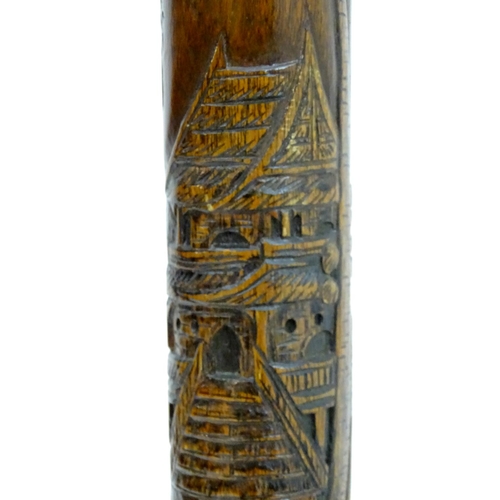 2248 - A 1920s Oriental mahogany standard lamp, decorated with carved island scenes with huts, boats and pa... 