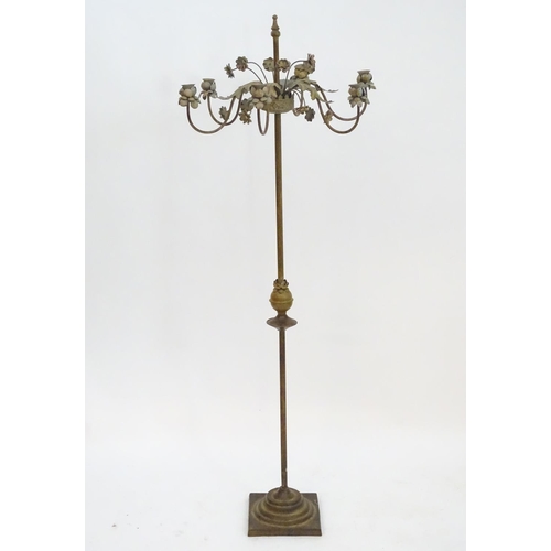 2250 - An early to mid 20thC patinated metal floor standing candelabra, the six cups formed as flower heads... 