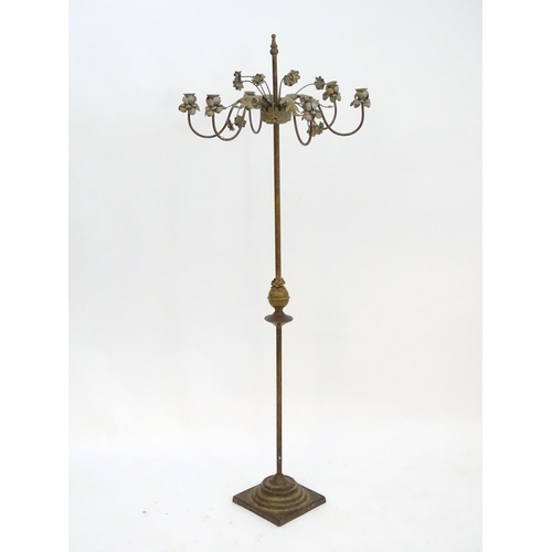 2250 - An early to mid 20thC patinated metal floor standing candelabra, the six cups formed as flower heads... 