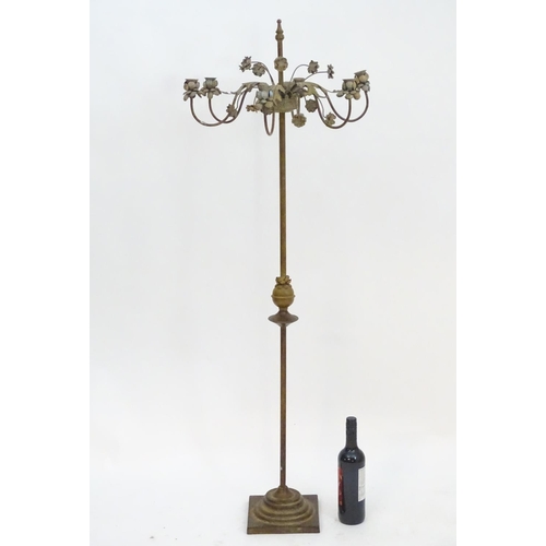 2250 - An early to mid 20thC patinated metal floor standing candelabra, the six cups formed as flower heads... 