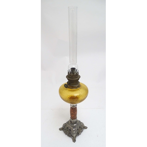 2254 - A late 19thC oil lamp, the silver plated base supporting a granite column below a peach glass reserv... 