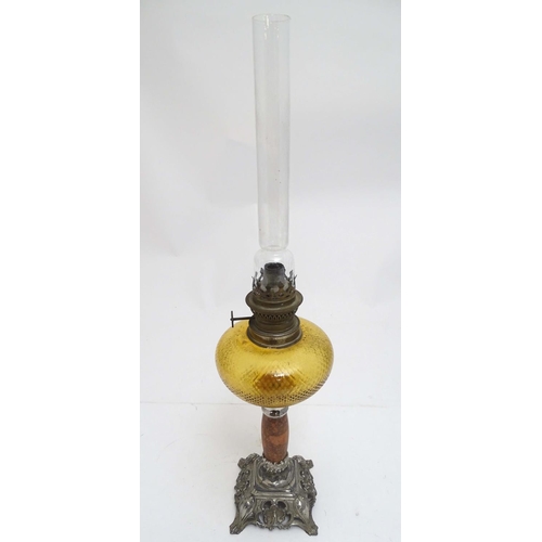 2254 - A late 19thC oil lamp, the silver plated base supporting a granite column below a peach glass reserv... 