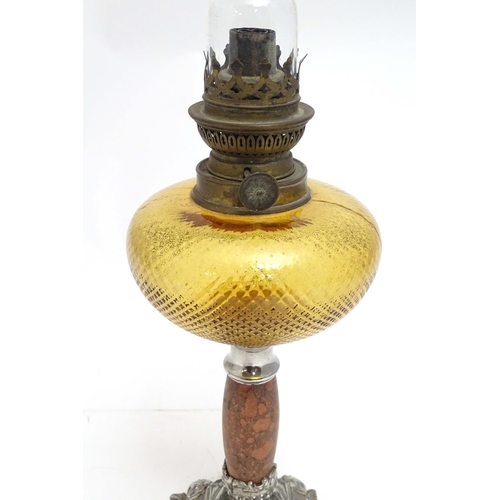 2254 - A late 19thC oil lamp, the silver plated base supporting a granite column below a peach glass reserv... 