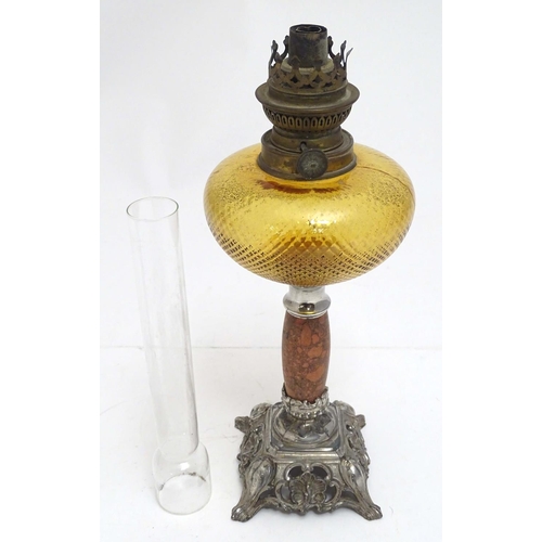 2254 - A late 19thC oil lamp, the silver plated base supporting a granite column below a peach glass reserv... 