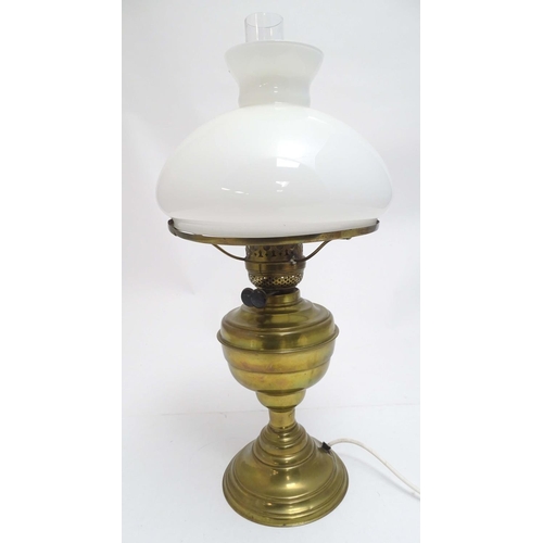 2256 - An early 20thC brass oil lamp, converted to electricity, the lobed body supporting a milk glass shad... 