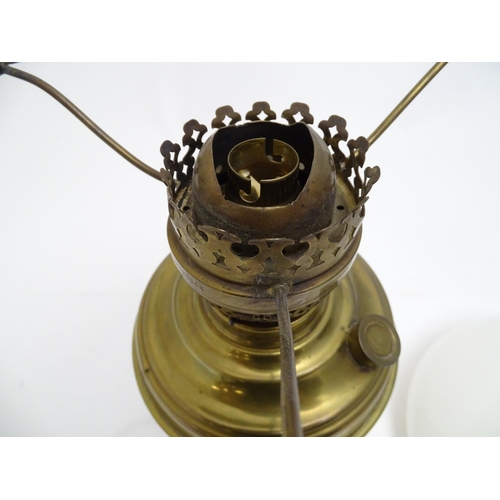 2256 - An early 20thC brass oil lamp, converted to electricity, the lobed body supporting a milk glass shad... 