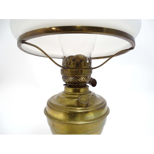 2256 - An early 20thC brass oil lamp, converted to electricity, the lobed body supporting a milk glass shad... 