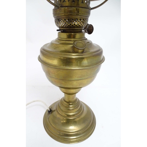 2256 - An early 20thC brass oil lamp, converted to electricity, the lobed body supporting a milk glass shad... 