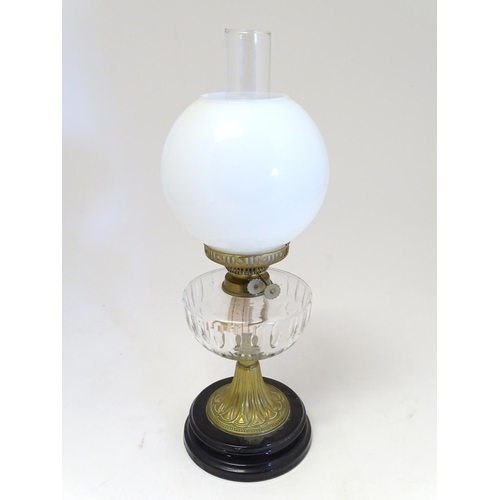 2259 - An early 20thC oil table lamp, the white globular glass shade supported by a clear cut glass reservo... 