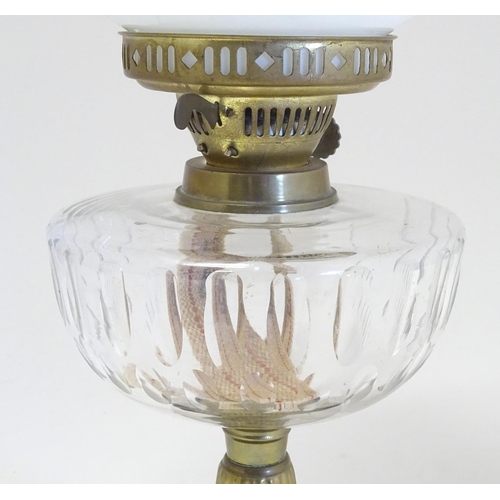 2259 - An early 20thC oil table lamp, the white globular glass shade supported by a clear cut glass reservo... 