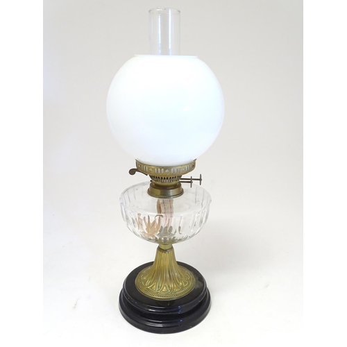 2259 - An early 20thC oil table lamp, the white globular glass shade supported by a clear cut glass reservo... 