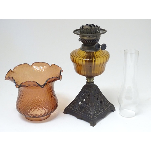 2265 - A late 19thC Duplex oil lamp, with bronzed glass shade and reservoir, standing on a cast iron base w... 