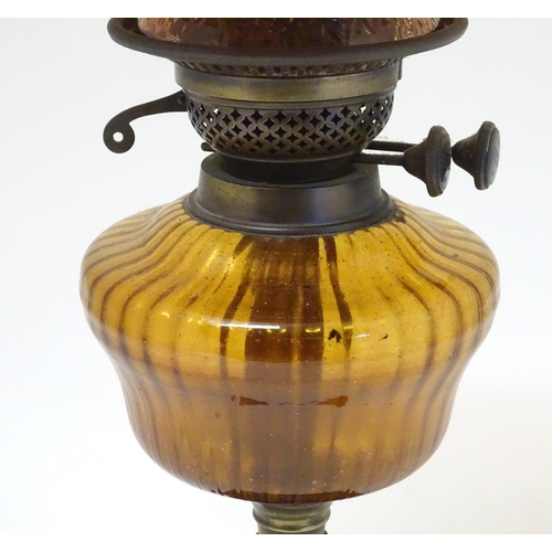 2265 - A late 19thC Duplex oil lamp, with bronzed glass shade and reservoir, standing on a cast iron base w... 