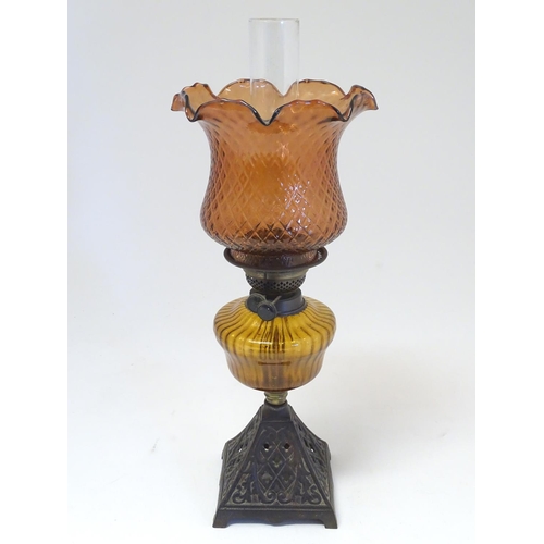 2265 - A late 19thC Duplex oil lamp, with bronzed glass shade and reservoir, standing on a cast iron base w... 