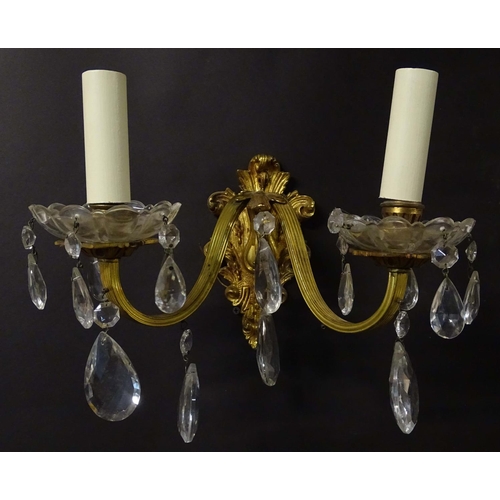 2269 - A pair of 20thC gilt twin branch wall lights, the gilt mounts supporting cut glass cups with droplet... 