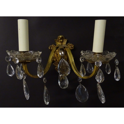 2269 - A pair of 20thC gilt twin branch wall lights, the gilt mounts supporting cut glass cups with droplet... 