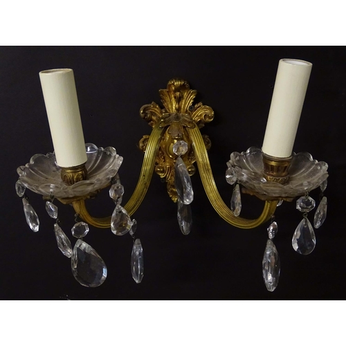 2269 - A pair of 20thC gilt twin branch wall lights, the gilt mounts supporting cut glass cups with droplet... 