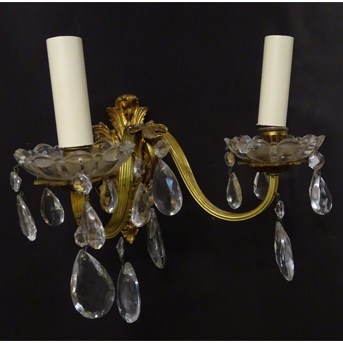 2269 - A pair of 20thC gilt twin branch wall lights, the gilt mounts supporting cut glass cups with droplet... 