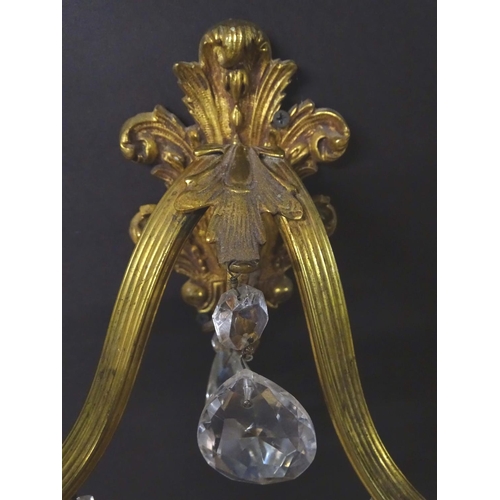 2269 - A pair of 20thC gilt twin branch wall lights, the gilt mounts supporting cut glass cups with droplet... 