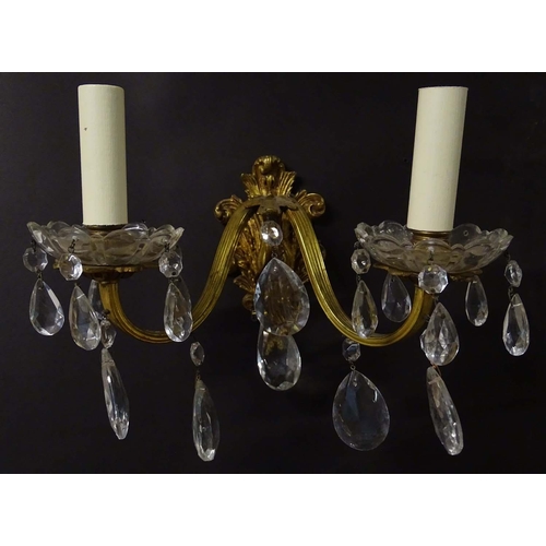 2269 - A pair of 20thC gilt twin branch wall lights, the gilt mounts supporting cut glass cups with droplet... 