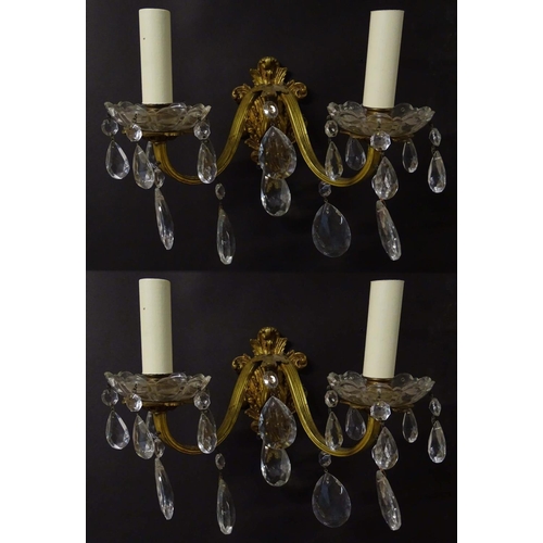 2269 - A pair of 20thC gilt twin branch wall lights, the gilt mounts supporting cut glass cups with droplet... 