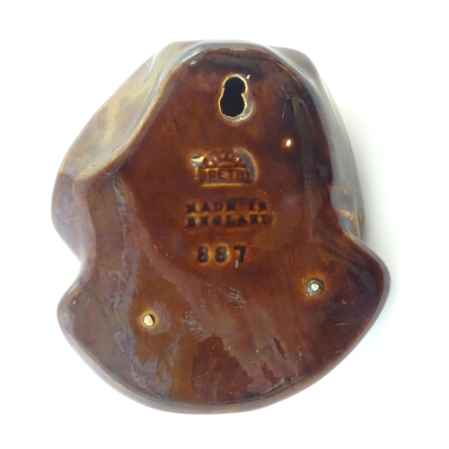 108 - A Bretby treacle glaze wall pocket modelled as a male head. Marked under, pattern number 887. Approx... 