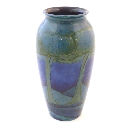 116 - An Art Nouveau Moorcroft vase in the pattern Moonlit Blue decorated with trees in a landscape with r... 