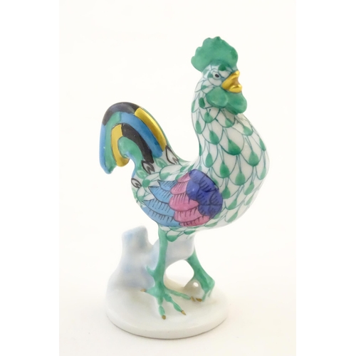 121 - A Herend pottery model of a cockerel with fishnet decoration and gilt highlights. Marked under. Appr... 