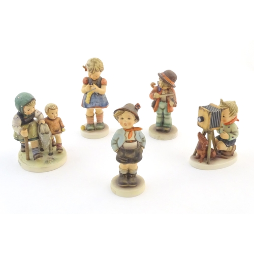 135 - Five Hummel / Goebel figures comprising The Photographer, no. 179, Homeward Bound, no. 334, Little F... 