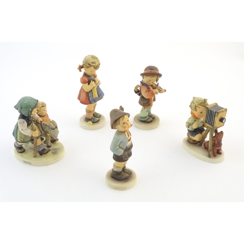 135 - Five Hummel / Goebel figures comprising The Photographer, no. 179, Homeward Bound, no. 334, Little F... 