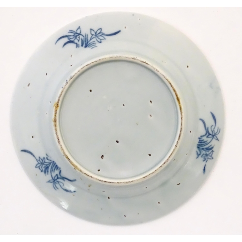 28 - A Chinese blue and white plate depicting a landscape scene with figures, trees, pagodas etc. with a ... 