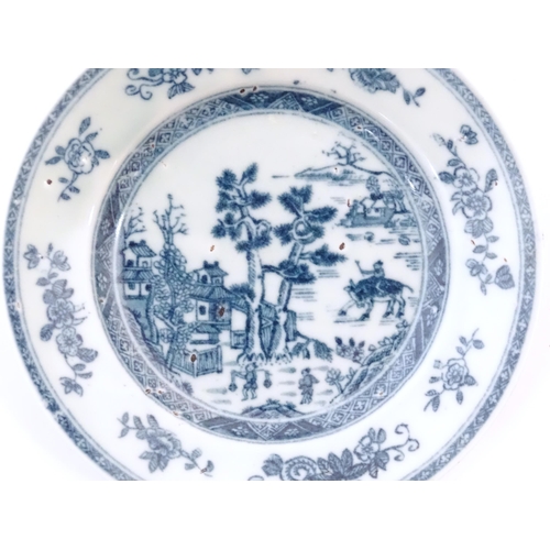 28 - A Chinese blue and white plate depicting a landscape scene with figures, trees, pagodas etc. with a ... 