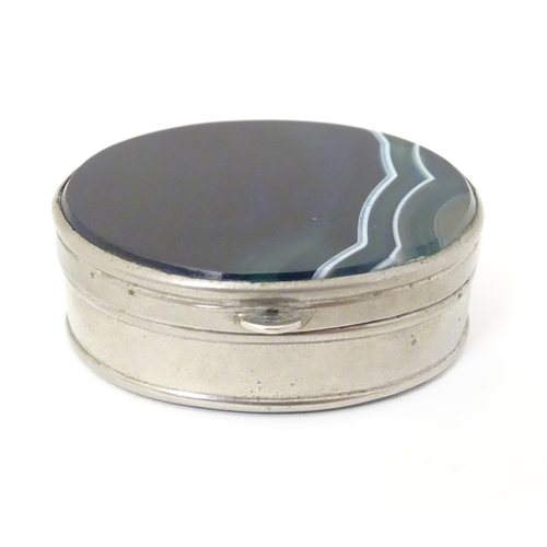 326 - A silver plate pill box of oval form set with blue banded agate to lid and base. Approx 2