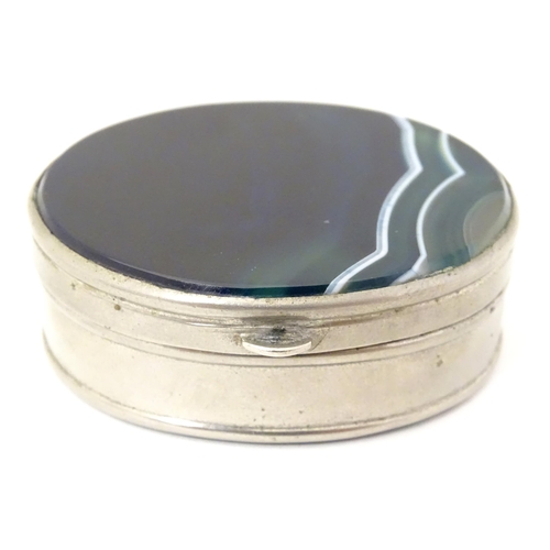 326 - A silver plate pill box of oval form set with blue banded agate to lid and base. Approx 2