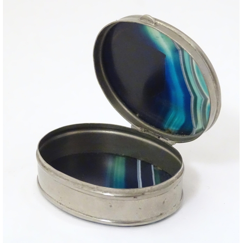 326 - A silver plate pill box of oval form set with blue banded agate to lid and base. Approx 2