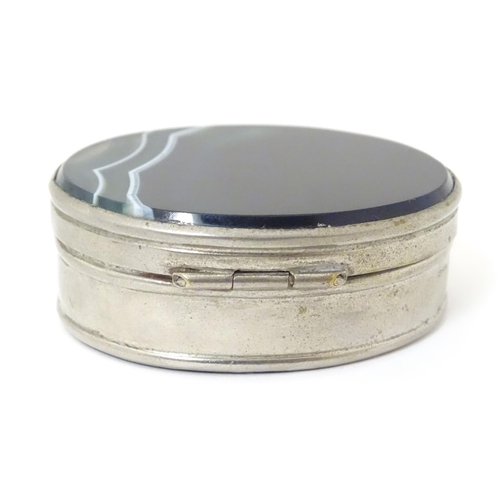 326 - A silver plate pill box of oval form set with blue banded agate to lid and base. Approx 2