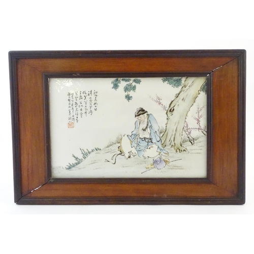 36A - A Chinese porcelain plaque decorated with a seated elder / scholar beneath a tree, with Oriental scr... 